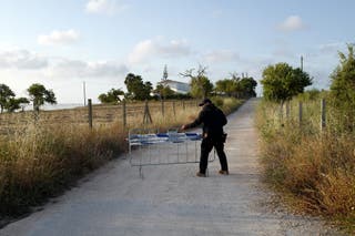 The policeman moves barriers who block their way because the police continues the search for Madeleine McCann's body in Atalaia, Portugal
